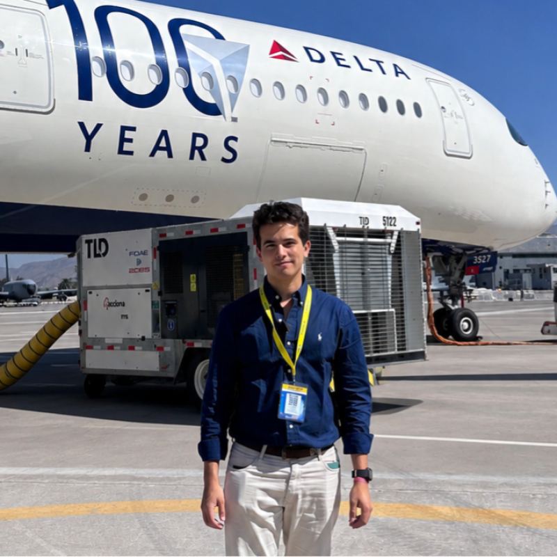 Gabriel Alvarez frente a un avión Delta en plataforma aeroportuaria